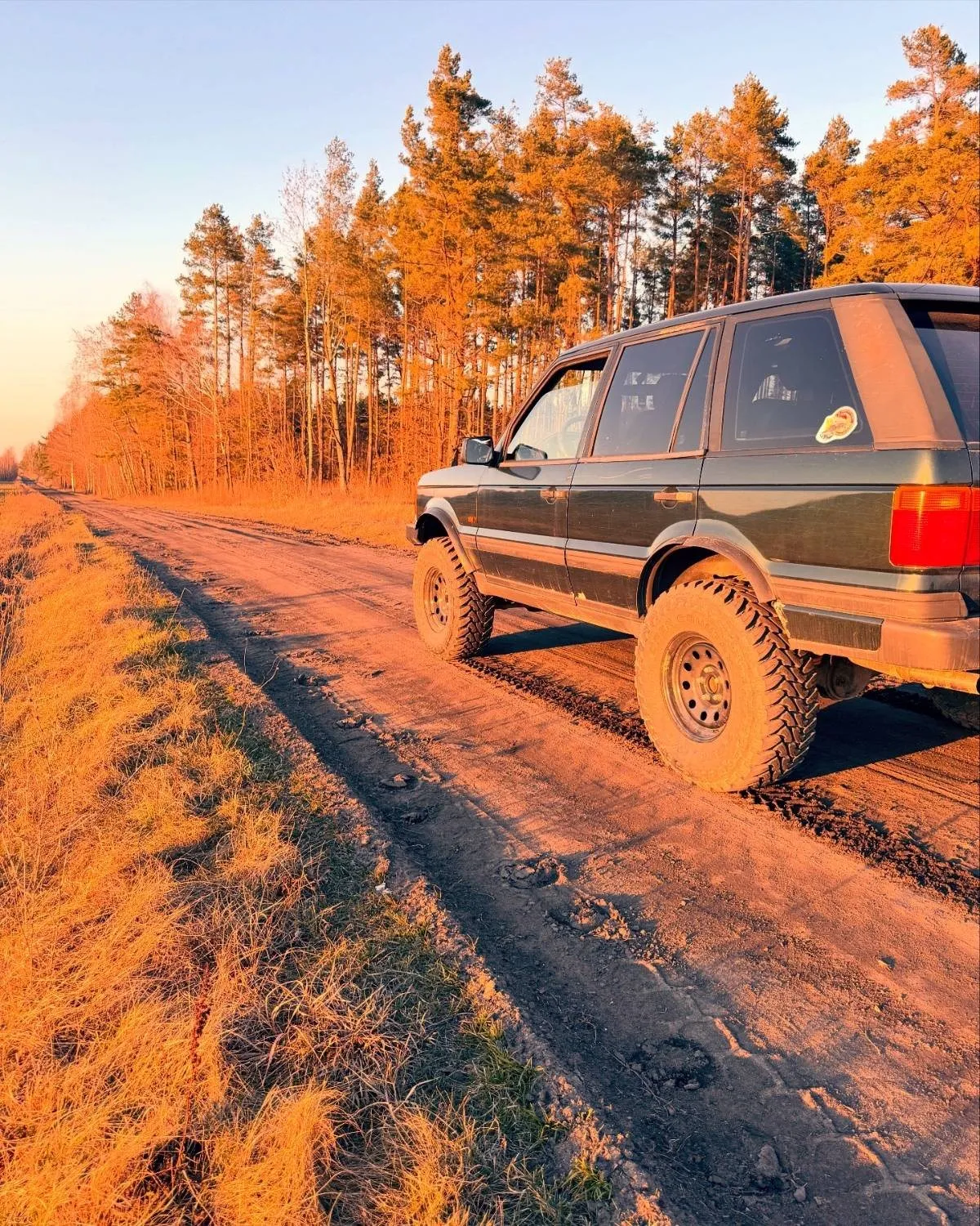 Range Rover na piaszczystej drodze w świetle zachodu