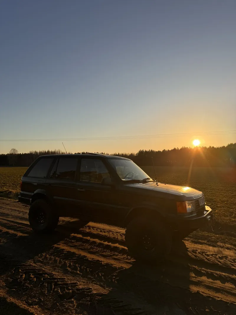 Range Rover pod słońce na polnej drodze